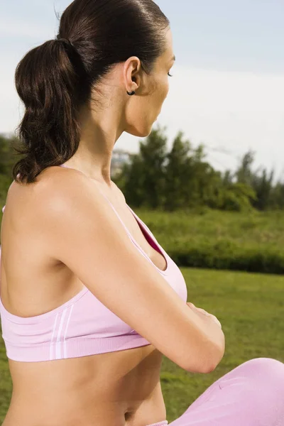 Side profile of a young woman stretching