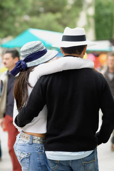 Rear view of a man and a woman with their arms around each other