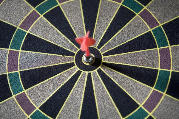 Close-up of a dart in the bulls-eye of a dart board