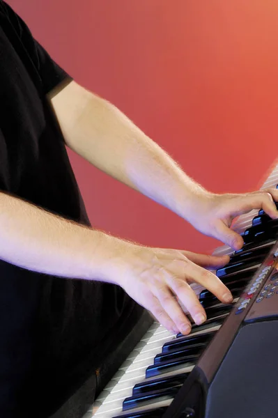 Close-up of a musician's hands playing the synthesizer