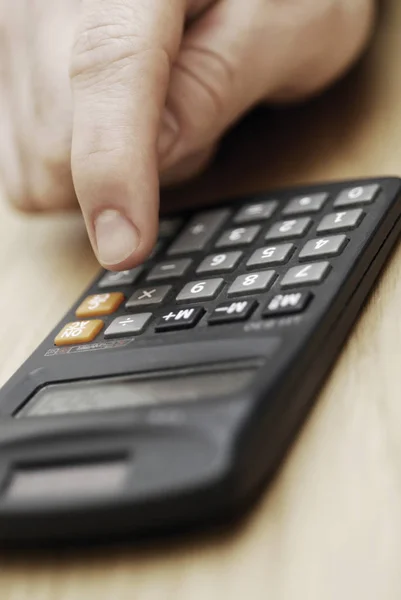 Close-up of a person\'s hand using a calculator