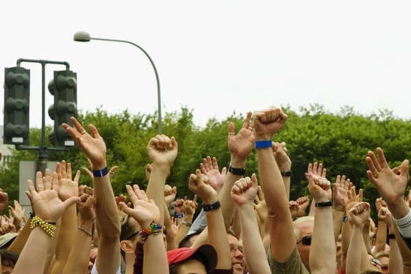 Large group of people waving their arms at a gay parade