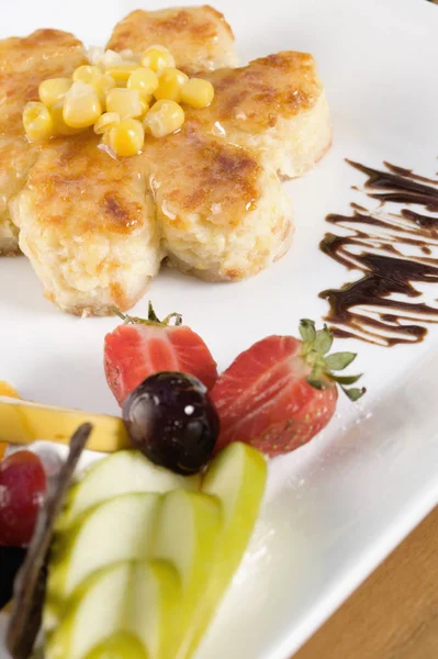 Close-up of corn cakes and fruits in a plate