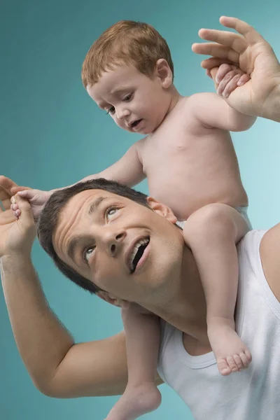 Close-up of a mid adult man carrying his son on his shoulders