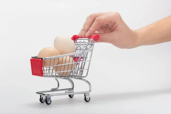 購入者の手は鶏の卵と食料品のカートを運ぶ — ストック写真
