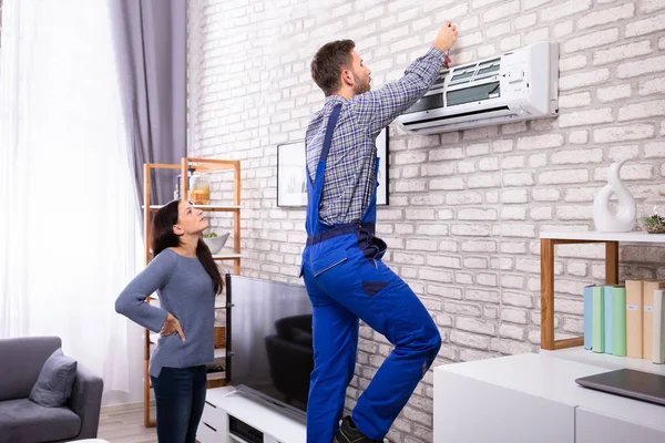 Young Woman Looking Male Technician Repairing Air Conditioner Mounted Brick — Stock Photo, Image