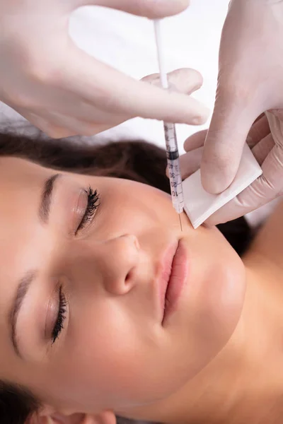審美的な治療を受けている女性の額に注射を与える美容師 — ストック写真