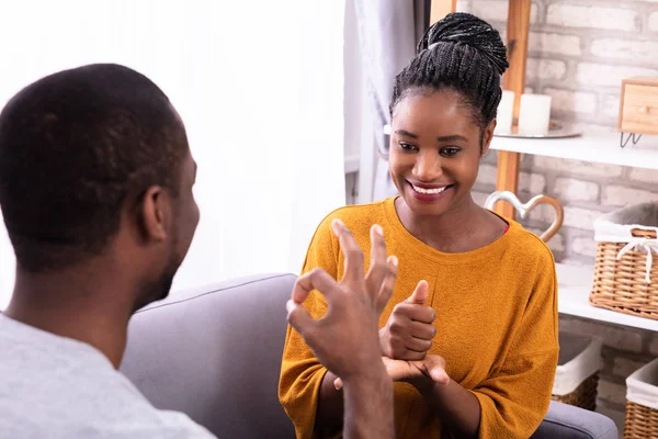 Smiling Young Couple Sitting Sofa Communicating Sign Languages — Stock Photo, Image