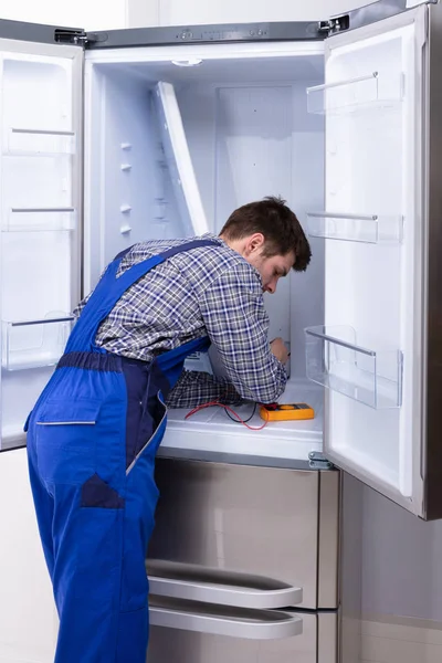 Young Serviceman Checking Fridge Digital Multimeter — Stock Photo, Image