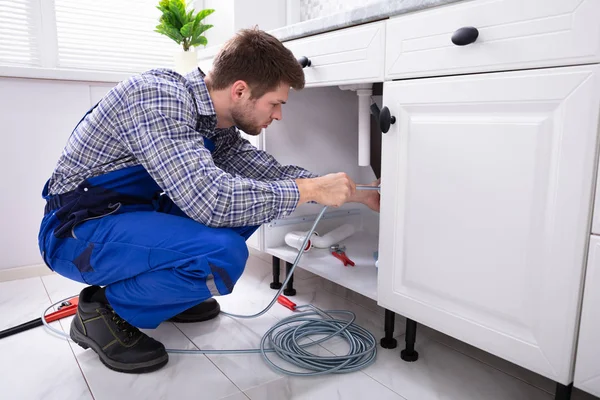 Young Male Plumber Cleaning Clogged Sink Pipe Kitchen — Stock Photo, Image