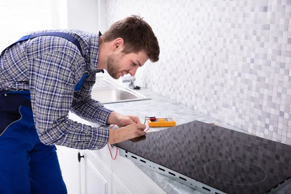 Side View Young Repairman Examining Induction Stove Digital Multimeter — Stock Photo, Image