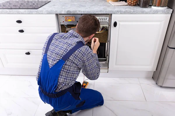 Jovem Reparador Fixando Máquina Lavar Louça Com Multímetro Digital Cozinha — Fotografia de Stock