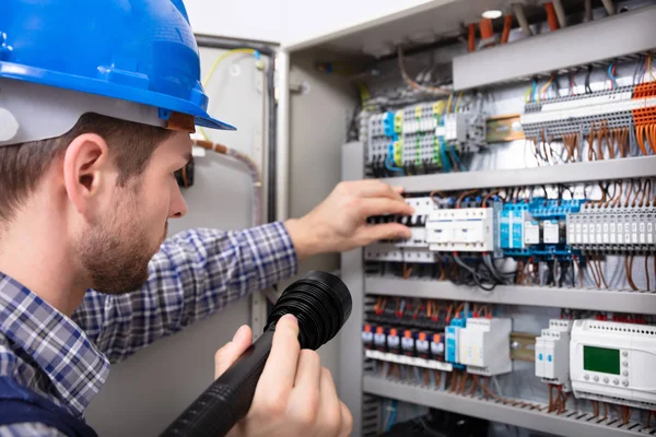 Close Electrician Examining Fuse Box Torch Stock Image