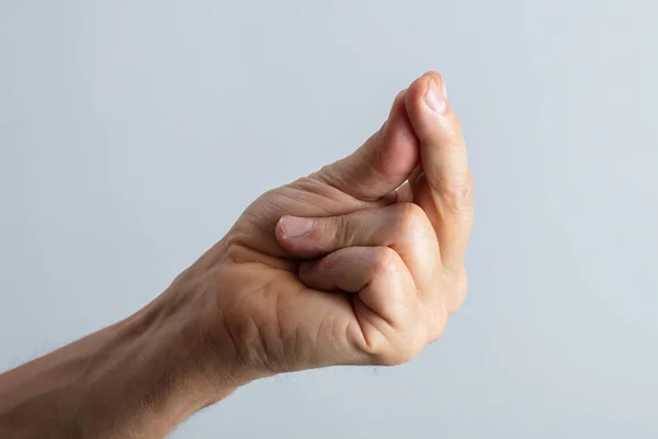 Zbliżenie Człowieka Ręka Pstrykając Jego Palec Szarym Tle — Zdjęcie stockowe