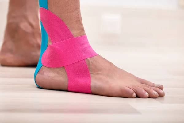 Detailní Záběr Mužské Nohy Fyziologickou Páskou Stojící Podlaze Tvrdého Dřeva — Stock fotografie