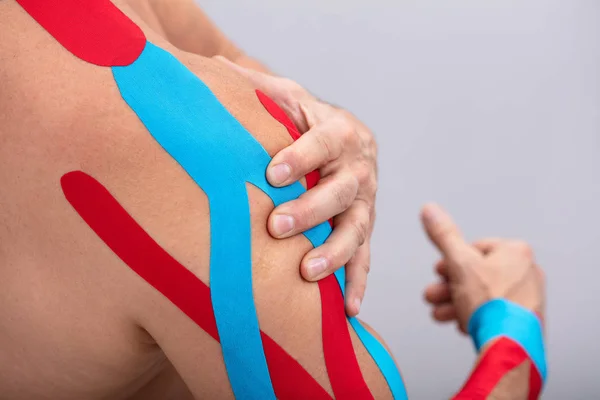 Primo Piano Dell Uomo Muscolare Con Nastro Fisioterapico Sulla Spalla — Foto Stock