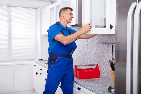 Side View Male Handyman Fixing Cabinet Door Using Screwdriver Kitchen — стоковое фото