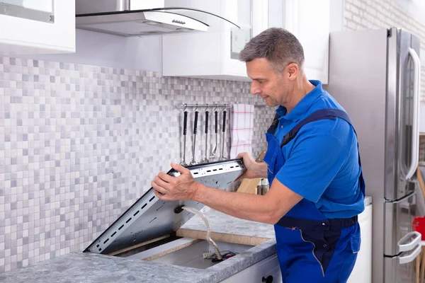 Mature Repairman Installing Induction Stove Kitchen — Stock Photo, Image