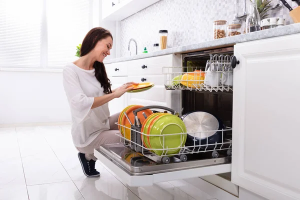 Smiling Young Woman Arranging Plates Dishwasher Home — Stock Photo, Image