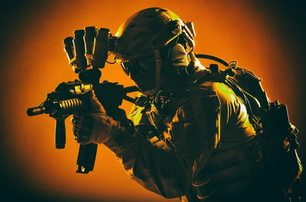 陸軍特殊作戦兵士 完全な戦術的弾薬 無線ヘッドセットとナイト ビジョン デバイス ヘルメット部隊戦闘機が暗闇の中 低キーのスタジオ撮影で短砲身のアサルトライフルを目指してください — ストック写真