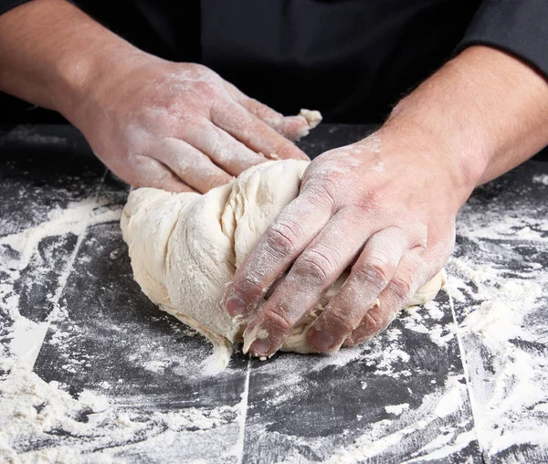 Baker Knådar Vit Vetemjöl Deg Svart Träbord Ovanifrån — Stockfoto