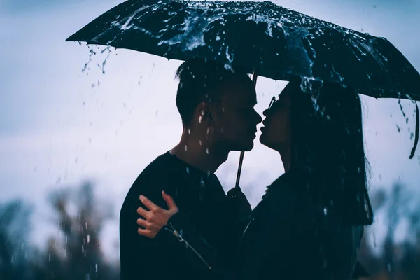 暗い傘の下に立つ若い夫婦は — ストック写真