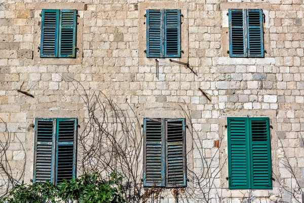 Six windows on a historic building in the historic center of Kotor, Monenegro