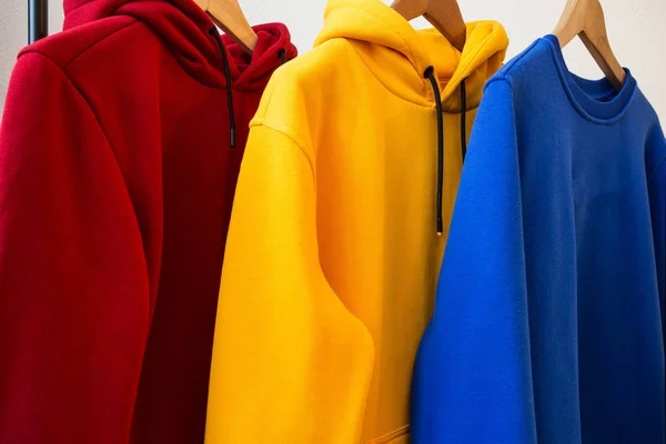 Askıları Kapısı Modern Tasarım Kumaş Dokusu Üzerinde Renkli Hoodies — Stok fotoğraf