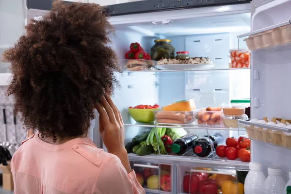 Vista Trasera Una Mujer Confusa Buscando Comida Refrigerador Abierto — Foto de Stock