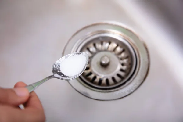 Person Putting Baking Soda Spoon Drain Washbasin — Stok Foto