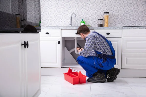 キッチンでの赤いツールボックス固定シンク以外の男性配管工 — ストック写真