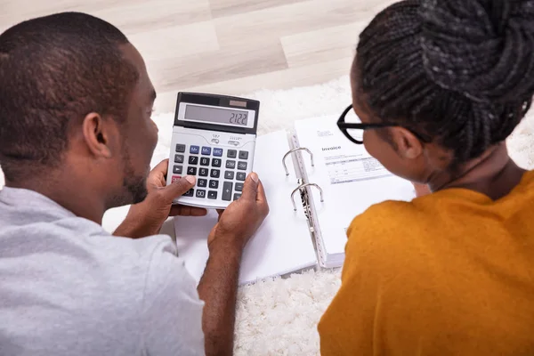 Young African Couple Lying Carpet Invoice Calculator — Stock Photo, Image