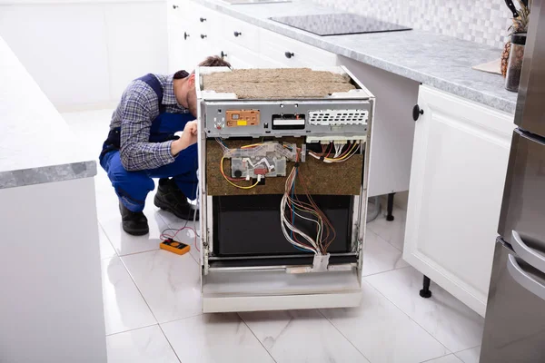 Junger Reparateur Repariert Geschirrspüler Mit Digitalem Multimeter Der Küche — Stockfoto