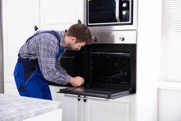 Joven Reparador Con Destornillador Fijación Horno Cocina —  Fotos de Stock