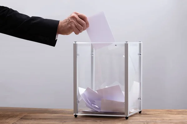 Nahaufnahme Der Hand Eines Geschäftsmannes Der Stimmzettel Eine Glasbox Einwirft — Stockfoto