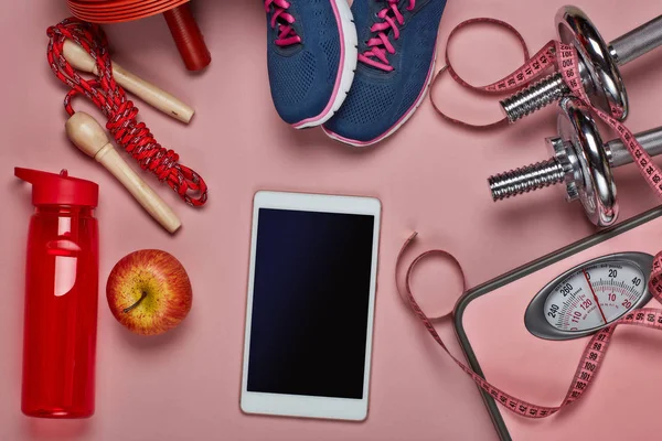 여성의 건강은 여전히 스포츠 액세서리 분홍색 컴퓨터 태블릿 다이어트와 훈련을 — 스톡 사진