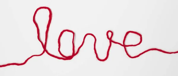 Palabra Amor Escrito Con Hilo Rojo Sobre Fondo Blanco —  Fotos de Stock