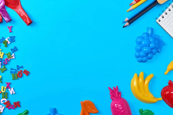 Niebieskie Tło Plastikowymi Zabawkami Dla Dzieci Ołówkami Balonami Drewnianymi Literami — Zdjęcie stockowe
