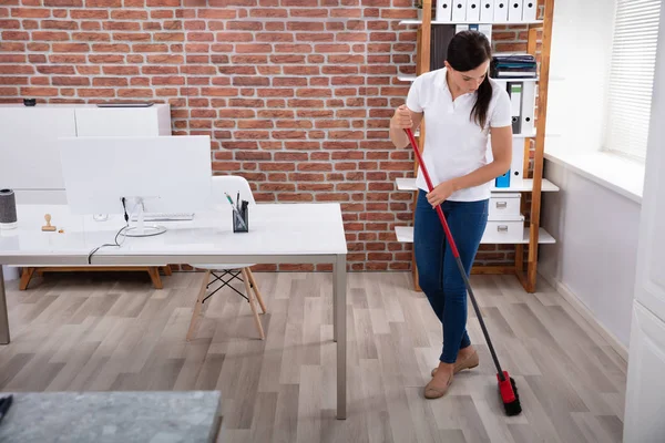 Happy Young Female Janitor Cleaning Floor Broom Office — стоковое фото