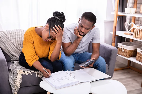 Triste Pareja Africana Sentada Sofá Examinando Factura — Foto de Stock