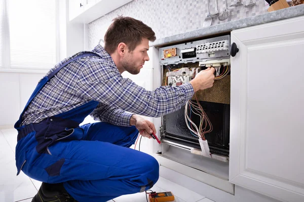 Técnico Masculino Comprobando Lavavajillas Con Multímetro Digital Cocina — Foto de Stock