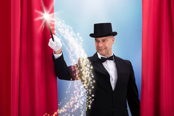 快乐的魔术师 头戴黑帽 带着发亮的魔杖做魔法 — 图库照片