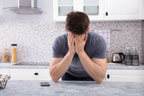Frustrado Homem Cobrindo Seu Rosto Com Duas Mãos Sentado Cozinha — Fotografia de Stock