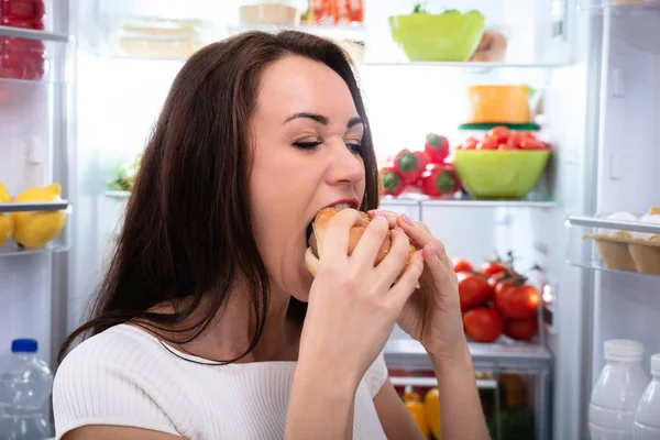 Lächelnde Junge Frau Blickt Auf Burger Der Vor Kühlschrank Steht — Stockfoto