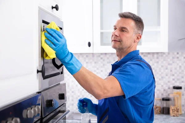 Вид Збоку Чоловічий Janitor Очищення Піч Жовтим Серветкою Кухні — стокове фото