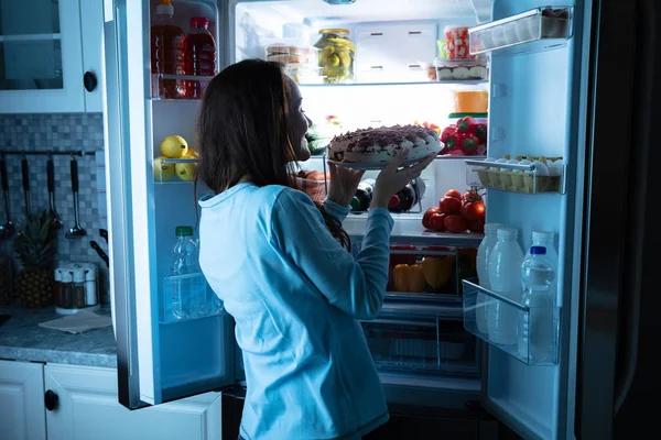 Mujer Joven Sonriente Mirando Pastel Frente Refrigerador Abierto — Foto de Stock