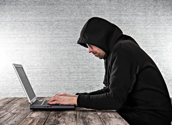 Hacker Felpa Nera Con Cappuccio Laptop Davanti Sfondo Grigio — Foto Stock