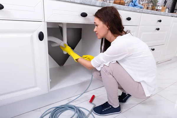 Vista Lateral Uma Jovem Mulher Limpeza Entalhada Tubo Pia Cozinha — Fotografia de Stock