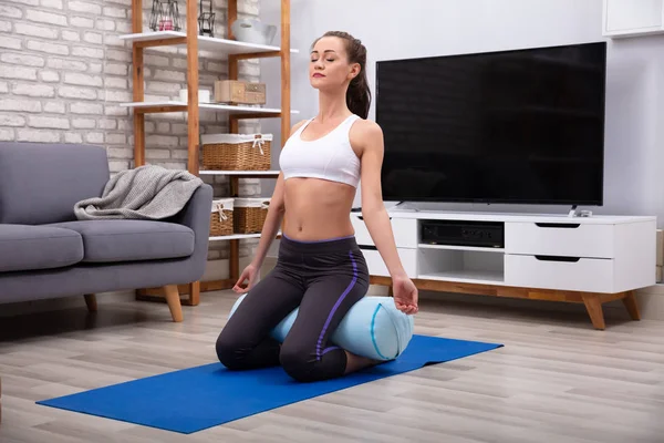 Genç Kadın Evde Yoga Bolster Üzerinde Uygulamak — Stok fotoğraf