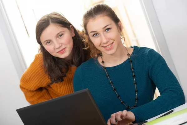 年轻女子帮助一个十几岁的女孩与家庭作业 — 图库照片
